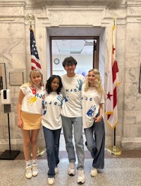 a group of people standing in front of a building wearing t - shirts