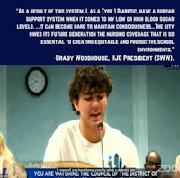 a man is speaking into a microphone in front of a group of people